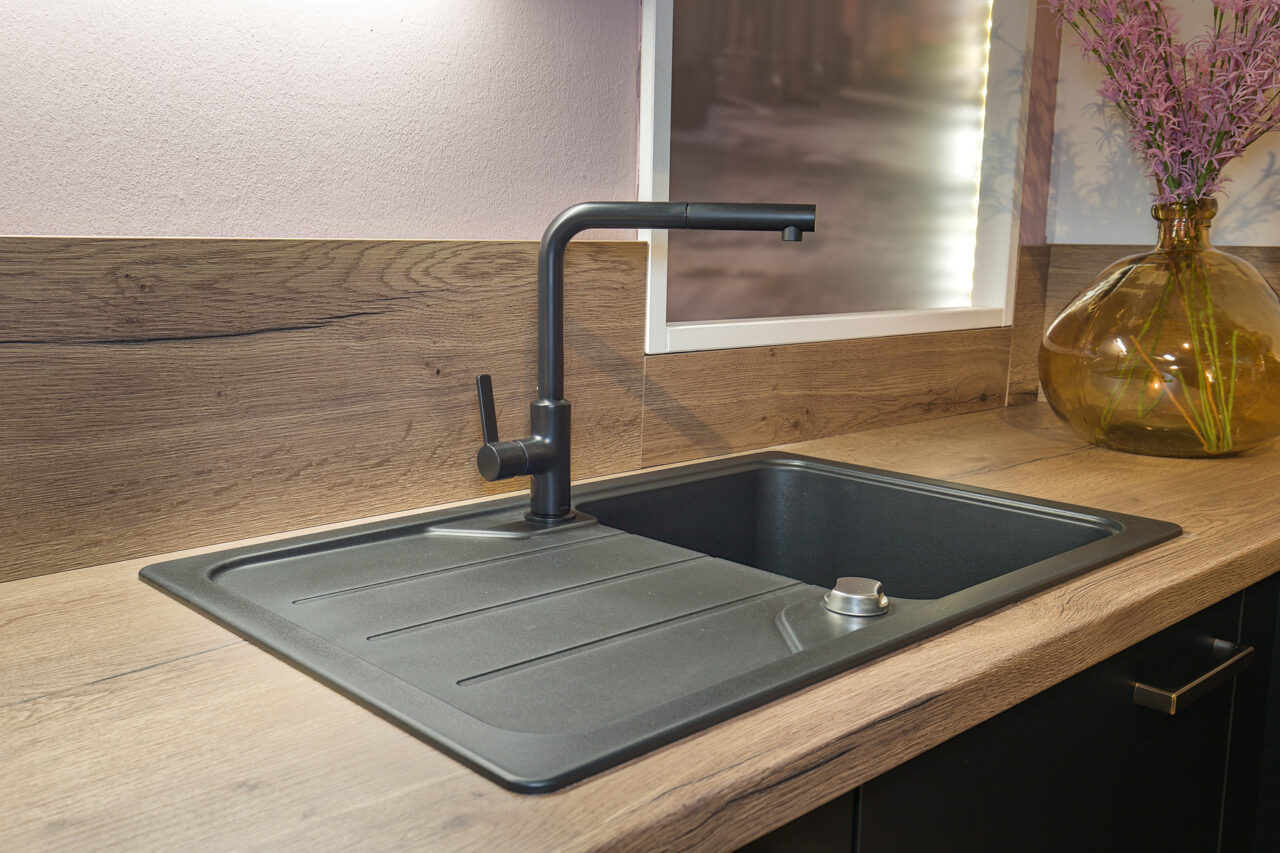 LINEA Touch schwarz – Koje 46 LINEA TOUCH in (340) Lacklaminat, Schwarz supermatt LINEA-DIE KÜCHE kombiniert mit INOVEL in (216) Lacklaminat, Stahl gebürstet Nachbildung